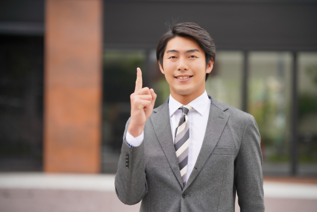 人差し指を立てる営業マン